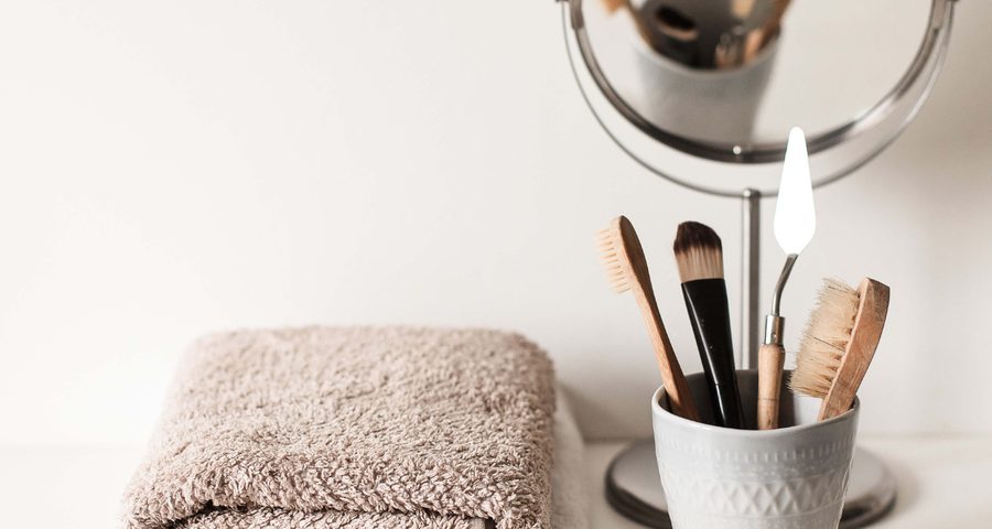 Serviettes pliées, miroir et pinceaux de maquillage