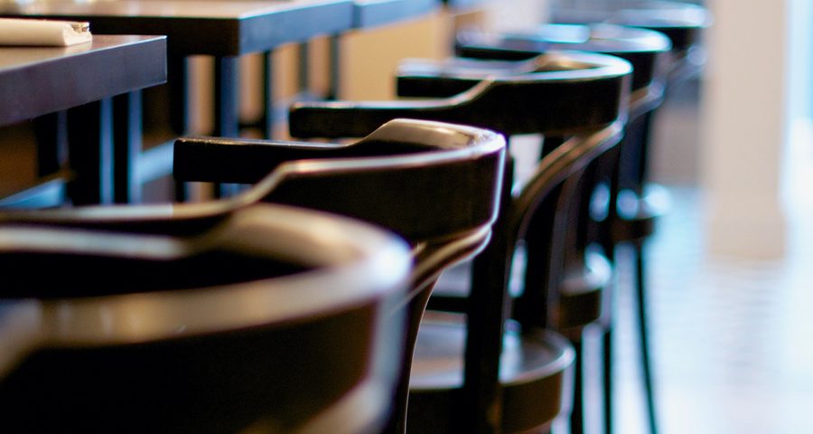 Salle d'un restaurant, chaises en bois et tables dressées