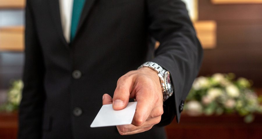 Réceptionniste d'hôtel tendant une carte-clé au comptoir