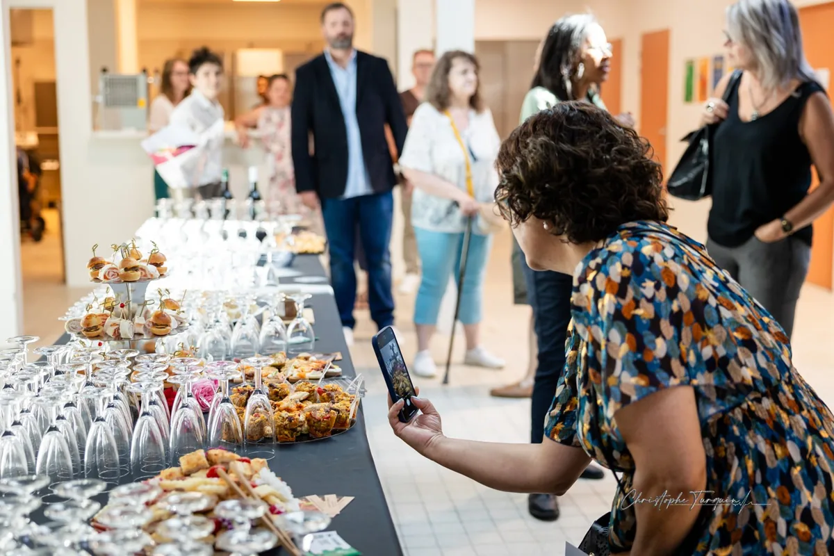 Une visiteuse photographie le buffet de l'inauguration de La Ruche Éco